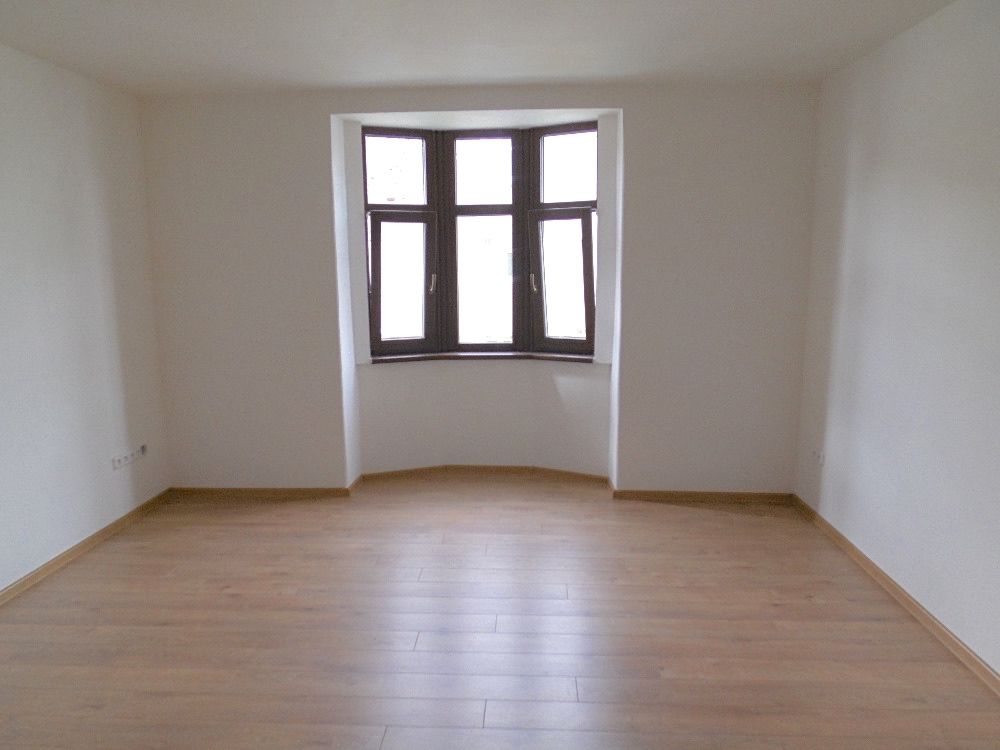 pokoj s dřevěnou podlahou a oknem