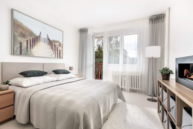 ložnice s manželskou postelí a velkým obrazem